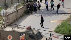 A molotov cocktail is thrown at an Israeli military vehicle during clashes in the flashpoint district of Jenin in the occupied West Bank, April 9, 2022.