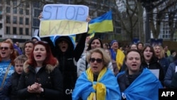 Para peserta demo dengan bendera Ukraina menggelar aksi di tengah aksi massa pendukung Rusia di Frankfurt am Main, Jerman, pada 10 April 2022. (Foto: AFP/Yann Schreiber)