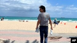 Huston Ochoa, a clinical counselor for The Spot, hands out samples of Narcan, which can reduce opioid overdoses, to spring breakers on Fort Lauderdale Beach, Florida, March 31, 2022.