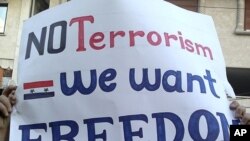 Protestors hold banners during a demonstration the Syrian port city of Banias, April 19, 2011