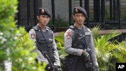 FILE - Armed police stand outside the Starbucks cafe where an attack occurred on Thursday, in Jakarta, Indonesia, Jan. 15, 2016. 