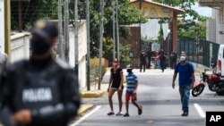 Security forces, back, leave a facility in the Macuto area in La Guiara, Venezuela, May 3, 2020. 