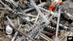 FILE - In this May 22, 2008 file photo, used syringes and needles are piled on the ground under an underpass on the west side of San Antonio where drug addicts shoot up.