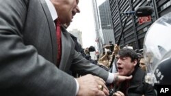 A New York City policeman keeps a demonstrator affiliated with the Occupy Wall Street movement from entering Zuccotti Park Tuesday, Nov. 15, 2011
