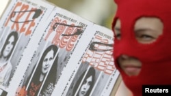 Seorang aktivis di Praha, Ceko, Jumat (17/8), mengenakan penutup wajah sebagai bentuk dukungan terhadap para anggota band Pussy Riot, yang dijatuhi hukuman penjara dua tahun.