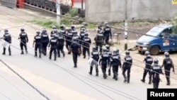A still image taken from video shows riot police walk along a street in the English-speaking city of Buea, Cameroon Oct. 1, 2017.