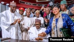Nigerian President Muhammadu Buhari signs an agreement during African Union summit in Niamey