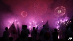 Quelques personnes regardent les feux d'artifice lors d'un événement pour marquer le début du compte à rebours de 500 jours avant les Jeux d'hiver olympiques Séoul 2018 à PyeongChang, Corée du Sud, 27 septembre 2016.