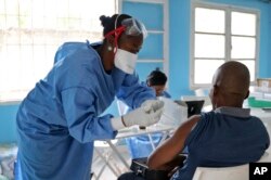 A World Health Organization aid worker from the Democratic Republic of the Congo gets vaccinated in Mbandaka, May 30, 2018. More than 680 people have received Ebola vaccinations in the three health zones where dozens of cases of the deadly virus have been