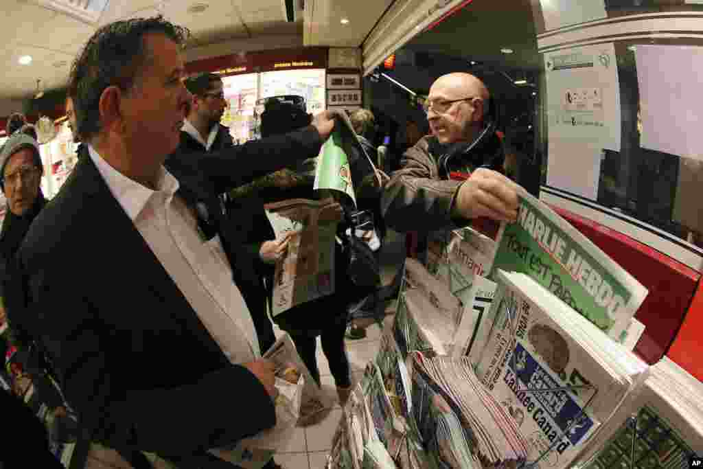 Warga mengambil tabloid&nbsp;Charlie Hebdo di kios koran di Rennes, selatan Perancis (14/1). (AP/David Vincent)