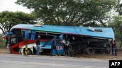 People inspect the wreckage of one of two buses that collided Nov. 7, 2018, along the Harare-Mutare highway near Rusape, Zimbabwe, Nov. 8, 2018.