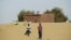 FILE - Boys walk on desert sands in the town of Moghtar-Lajjar in west Africa's Sahel region, where the United Nations says civil unrest and a drought have put 18 million people in food insecurity, May 25 2012.