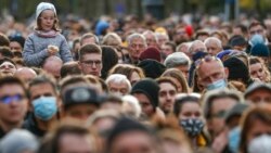A child sits on a man's shoulders as Hungarian opposition supporters listen to a speech by Prime Minister candidate Peter Marki-Zay during celebration the 65th anniversary of the 1956 Hungarian revolution, in Budapest, Oct. 23, 2021.