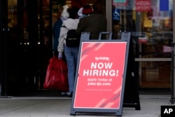 FILE - Hiring sign is displayed outside of a retail store in Vernon Hills, Illinois, Nov. 13, 2021.