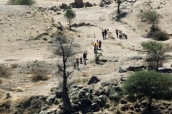 Ethiopians fleeing from the Tigray region walk towards a river to cross from Ethiopia to Sudan, near the Hamdeyat refugee transit camp, which houses refugees fleeing the fighting in the Tigray region, on the border in Sudan, Dec. 1, 2020.