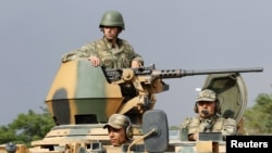 Turkish soldiers are seen on an armoured personnel carrier as part of a Turkish military convoy travelling on a main road leading to the southeastern Turkish city of Kilis July 30, 2012