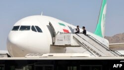FILE - Passengers get off from a privately owned Iranian airline Mahan Air flight at the airport in Kabul on Sept. 15, 2021