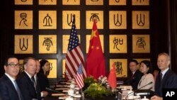 FILE - Chinese Vice Premier Liu He, right, sits with U.S. Trade Representative Robert Lighthizer, second from left, and Treasury Secretary Steven Mnuchin, left, before the start of talks at the Xijiao Conference Center in Shanghai, July 31, 2019.