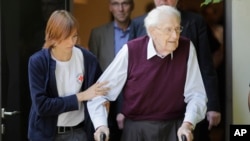 Petugas Palang Merah membantu mantan penjaga pasukan khusus Nazi, SS, Oskar Groening, meninggalkan persidangan setelah pembacaan vonis di Lueneburg, Jerman, 15 Juli 2015.