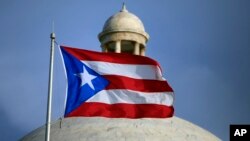 The Puerto Rican flag flies in front of Puerto Rico’s Capitol in San Juan, July 29, 2015. 