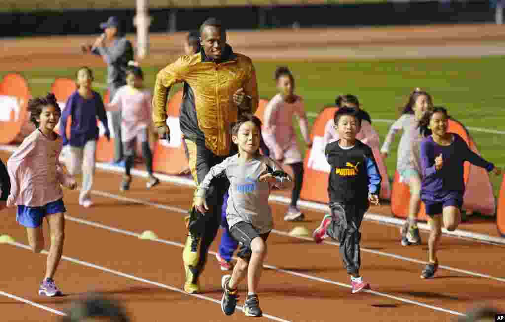 usain Bolt fait une compétition avec des enfant à&nbsp;Tokyo, Japon, le 22 November&nbsp;2013. 