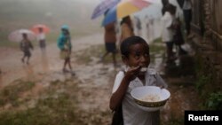ARSIP - Seorang siswa mengkonsumsi makan siang saat yang lain mengantri untuk mendapatkan jatah makan siangnya di sebuah sekolah di desa Letefoho di distrik Ermera, 13 Maret 2012 (foto: Reuters/Beawiharta)