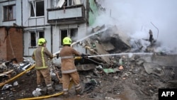 በዩክሬን ፖልተቫ የሚሳየል ጥቃት ከደረሰ በኋላ የእሳት አደጋ ሰራተኞች ለማጥፋት ሲረባረቡ ያሳያል፡፡ (Photo by SERGEY BOBOK / AFP)