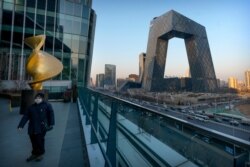 중국 베이징에 있는 CGTN 모회사 CCTV 사옥 앞으로 마스크를 착용한 시민이 지나가고 있다.