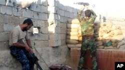 Iraqi security forces take combat positions at the front-line with Islamic State group militants as Iraqi Army and allied Sunni volunteer tribal fighters supported by U.S.-led coalition airstrikes on Ramadi, the capital of Iraq's Anbar province, 70 miles (115 kilometers) west of Baghdad, Iraq, Wednesday, Dec. 2, 2015. AP Photo.