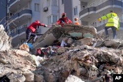 Tim SAR mencari orang di reruntuhan bangunan yang hancur di Adana, Turki selatan, Selasa, 7 Februari 2023. (Foto: AP)