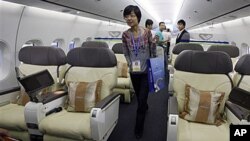 Visitors walk inside the cabin of a scale model of a Chinese-made C919 passenger airliner at the 8th China International Aviation and Aerospace Exhibition (Zhuhai Airshow) in Zhuhai, southern coast of Guangdong province, China, 16 Nov 2010.
