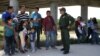 FILE - Border patrol agent Sergio Ramirez talks with migrants who illegally crossed the border from Mexico into the U.S., in the Rio Grande Valley sector, near McAllen, Texas, April 2, 2018.
