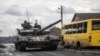 Ukrainian servicemen ride a tank in the village of Torske