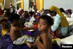A child, believed to be Rohingya, eats inside a shelter after he was rescued along with hundreds of others on Sunday from boats in Lhoksukon, Indonesia's Aceh Province, May 12, 2015.