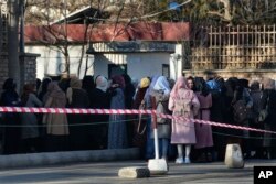 Mahasiswa Afghanistan antre di salah satu gerbang Universitas Kabul di Kabul, Afghanistan, pada 26 Februari 2022. (Foto: AP)