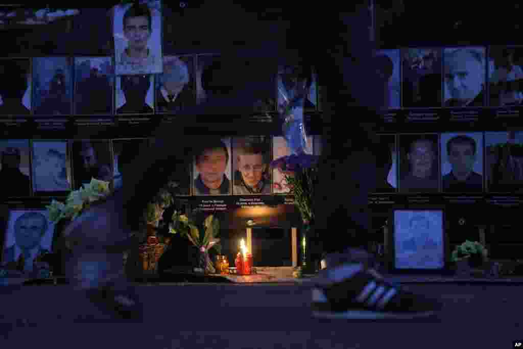 A woman walks past portraits of protesters who were killed in clashes with police in February in Independence Square in Kyiv, June 18, 2014. 