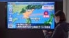 Žena prolazi pored TV-a koji emituje vijest o lansiranju projektila Sjeverne Koreje u četvrtak, 24. marta 2022., Tokio, Japan.