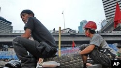 'Red Shirt' anti-government protesters sit on used tires as they prepare for a counter attack against a possible crackdown by the Thai military on their fortified camp in the financial district of central Bangkok, 27 Apr 2010