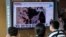 People watch a TV screen showing a file satellite image of the Yongbyon nuclear site in North Korea during a news program at the Seoul Railway Station in Seoul, South Korea, Aug. 30, 2021. 