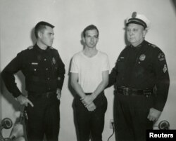 FILE - Lee Harvey Oswald, accused of assassinating U.S. President John F. Kennedy, is pictured with a Dallas police sergeant and an officer in this handout image taken Nov. 22, 1963.
