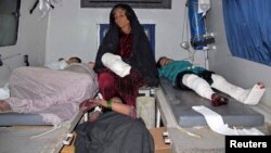 Injured Afghan civilians rest in an ambulance as they are brought to a hospital in Helmand province, December 31, 2014.