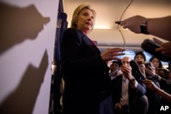 FILE - Democratic presidential candidate Hillary Clinton speaks to members of the media on board her campaign plane as she travels to Tampa, Sept. 6, 2016.