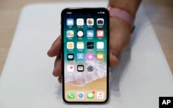 FILE - The new iPhone X is displayed in the showroom after the new product announcement at the Steve Jobs Theater on the new Apple campus in Cupertino, California, Sept. 12, 2017.