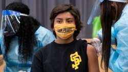 In this Monday, May. 24, 2021, photo high school student Alex Bugarin, 13, is vaccinated at a school-based COVID-19 vaccination clinic for students 12 and older at the LAUSD San Pedro High School John M. and Muriel Olguin Campus in San Pedro, Calif. (AP Photo)