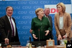 FILE - German Chancellor Angela Merkel, second from left, arrives with North Rhine-Westphalia state governor Armin Laschet (L), Hesse state governor Volker Bouffier (2nd from R), and Julia Kloeckner (R) for a board meeting of her Christian Democratic Union party at the headquarters in Berlin, Nov. 27, 2017.