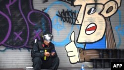 FILE - A Vietnamese policeman uses his mobile phone in Hanoi, Feb. 26, 2019.