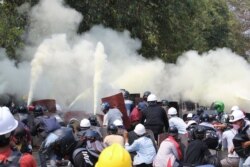 Anti-coup protesters discharge fire extinguishers to counter the impact of the tear gas fired by police during a demonstration in Naypyitaw, Myanmar, March 8, 2021.