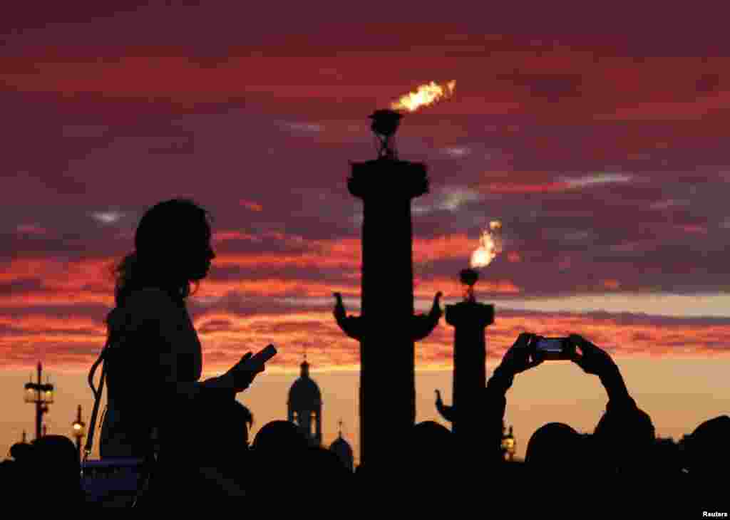 在俄罗斯圣彼得堡的红帆节，人们等待放烟花（6月23日）。红帆节是一年一度的庆祝中学生毕业的节日，让中学毕业生告别少年，在黎明来临之际迎接人生新阶段。