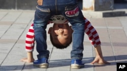 FILE - A child bends over in a public park in Yinchuan in northwestern China's Ningxia Hui autonomous region, Oct. 8, 2015. China this week officially ended its three-decade old one-child policy.