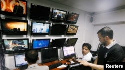 FILE - Afghan journalists work in the Tolo newsroom, in Kabul, Afghanistan, Sept. 7, 2018. 